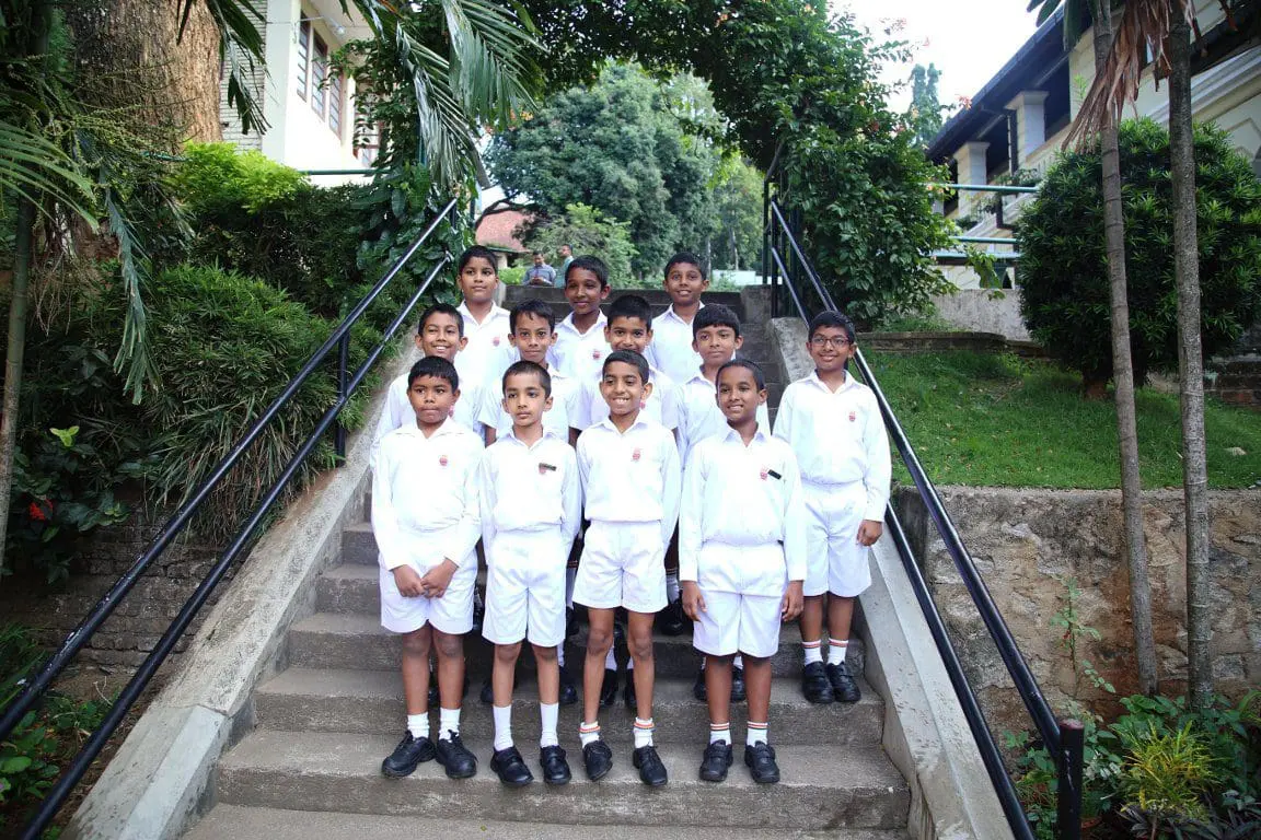 Group of 12 Junior School students from the Oriental Music Society standing on steps