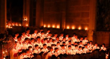 Choristers in chapel singing and holding candles